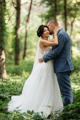 wedding walk of the bride and groom in the deciduous forest in summer
