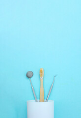 Different tools for dental care, toothbrush in plastic glass. Tooth symbol sign. Dental Hygiene and Health conceptual image.