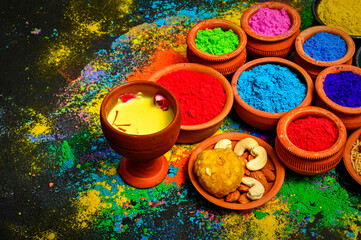 top view of colorful traditional holi powder in bowls isolated on dark background.Space for text . happy holi.Concept Indian color festival called Holi