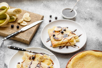 Delicious fresh baked pancakes with honey and fruits on a concrete background