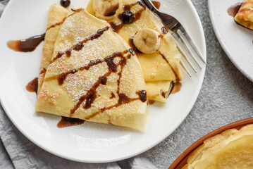 Delicious fresh baked pancakes with honey and fruits on a concrete background