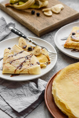 Delicious fresh baked pancakes with honey and fruits on a concrete background