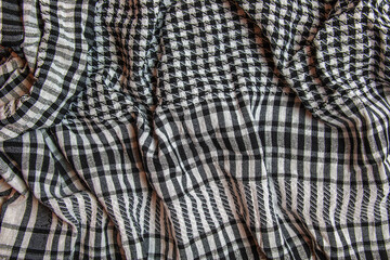 Background texture, pattern. Scarf wool like Yasser Arafat. The Palestinian keffiyeh is a gender-neutral checkered black and white scarf that is usually worn around the neck or head.