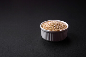 Wholesome raw quinoa in a bowl on a dark concrete background