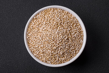 Wholesome raw quinoa in a bowl on a dark concrete background