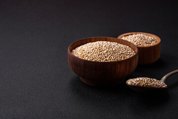 Wholesome raw quinoa in a bowl on a dark concrete background