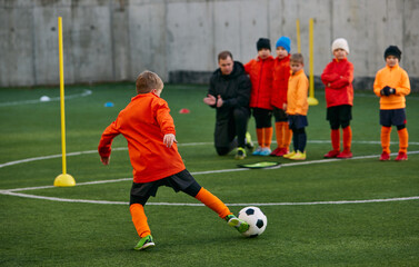 Little boy, child, football player in uniforma training outdoor at sports stadium. Dribbling ball. Concept of sport, childhood, active lifestyle, hobby, sport club