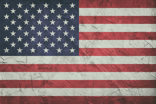 USA flag on stone wall, grunge background. USA flag depicted in bright paint colors on old relief plastering wall