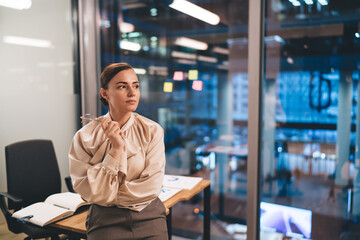Fototapeta premium Pensive businesswoman looking away in modern workplace