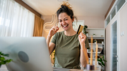 happy woman online shopping use credit card laptop computer at home
