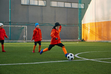 Position on field. Boy, child, playing football, training on sports field outdoor. Running with...