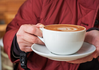 Hands of a woman holding cup of coffee. Time for drinking coffee. Coffee mug in a hands.