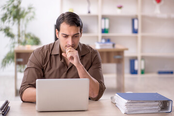 Young attractive employee sitting in the office