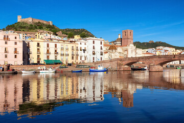 Fototapeta na wymiar River with Homes and Apartments in Touristic Town. Bosa, Sardinia, Italy. Sunny Fall Season Day. Panorama
