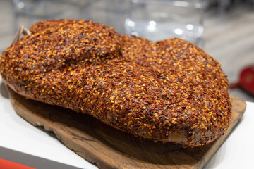 Cheese on a Wooden Cutting Board with an Outer Crust Flavored with Chili Pepper