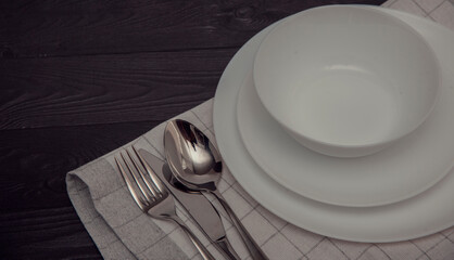White plates on the wooden surface ,linen napkin, top view of table place  