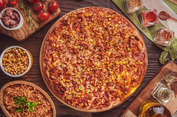 Brazilian pizza with mozzarella, chicken, calabrese sausage, bacon, corn, provolone and oregano (Pizza especial) - Top view.