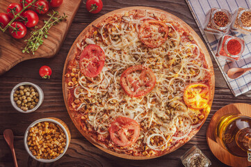 Brazilian pizza with mozzarella, corn, pea, tomato, onion, olive and oregano (Pizza vegetariana) - Top view.