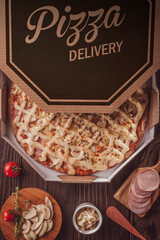 Brazilian pizza with mozzarella, pork loin, mushroons, catupiry and oregano in a delivery box (Pizza especial) - Top view.