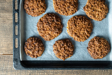 Delicious oatmeal cookies with walnuts on baking sheet, closeup, top view