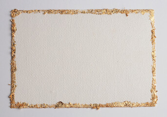 Gold (bronze) glitter empty canvas frame on beige gray paper background. Abstract copy space...