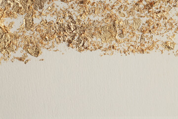 Gold (bronze) glitter, beige empty paper canvas background. Abstract copy space texture.