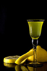 Macro Image Glass of Italian Liqueur with Lemons on Dark Background