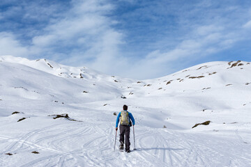 Fototapeta na wymiar Man is snowshoe hiking in alpine winter mountains. Berlingerskoepfle, Haehlekopf, Vorarlberg, Austria.