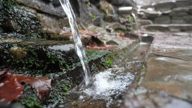 Mineral water source high in the mountains in winter, slow motion