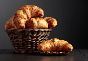 Fresh croissants on a black ceramic table.