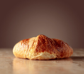 Croissant on a beige ceramic table.