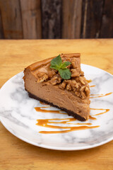 Desserts. Closeup view of a slice of dulce de leche cheesecake with nuts and caramel sauce. 