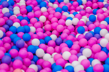 Background, texture of many colored, multi-colored round plastic small balls on the playground for children's games. Photography, top view, copy space, childhood concept, macro.