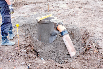 Groundworkers installing new road gully during new road construction