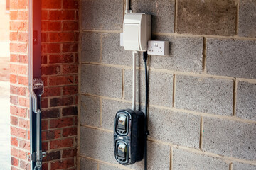 Electric vehicle domestic charging point installed outside of the house on new housing development as part of green energy program to allow recharging vehicle overnight