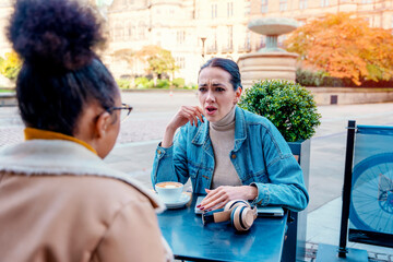 angry and unhappy woman in glasses  having an unpleasant conversation in cafe