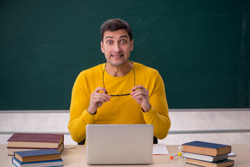 Young male student sitting in the classroom