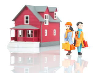 miniature people. romantic couple of young people near the house model on a white background. friendship and great relationship