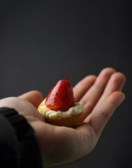 Mini Strawberry Tart in Hand Gray Background 