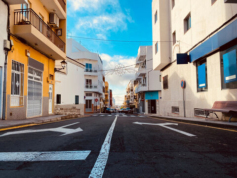 Stra&szlig;e darauf Richtungspfeile, in Valle de San Lorenzo, rechts und links bunte Hausfassaden