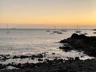 Sonnenuntergang an der Küste, Segelboote ankern im Meer.