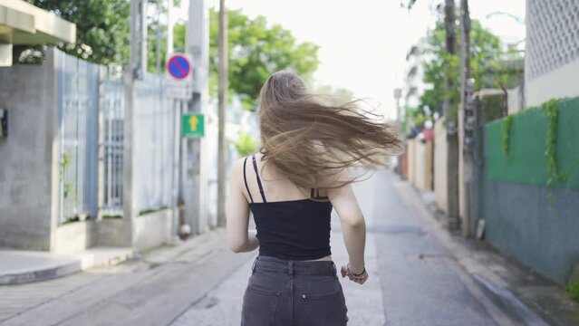 Portrait of Caucasian woman girl in yoga class club doing exercise, runing or jogging at urban city town street road. Outdoor sport and recreation. People lifestyle activity with nature trees view.