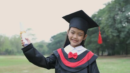 Educational concept of 4k Resolution. Asian girl confidently holding diploma on graduation day.