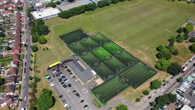 Aerial drone footage of the town of Wimbledon in the UK showing the football pitches of a 5 a side British soccer pitches on a hot sunny day in the summer time.
