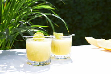 Refreshing summer cocktail, melon smoothie with ice and lime. The concept of vegetarian summer drinks. Ideal for detox