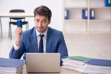 Young male employee and too much work in the office