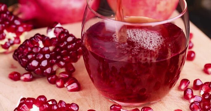 Red freshly squeezed pomegranate juice in a transparent glass, poured into a glass glass sweet and sour pomegranate juice