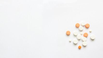 Assorted scattered pharmaceutical medicine pills and tablets in various colour and size isolated in white background, copy space for text or advertising