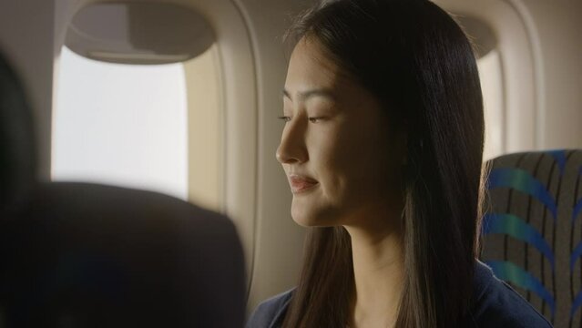 Asian woman on Airplane, happy