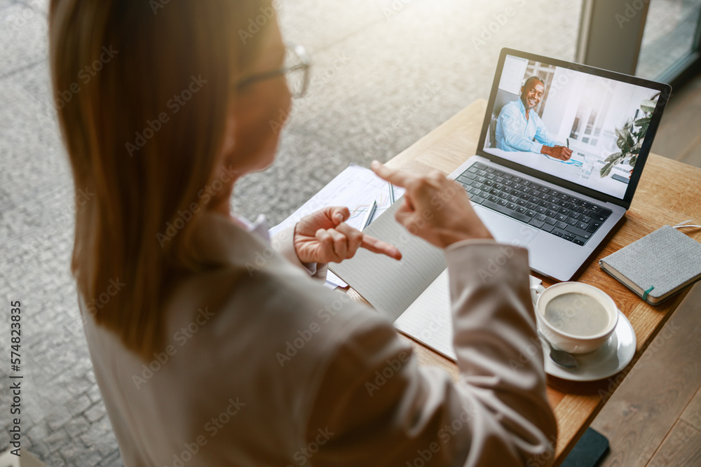 Wall mural close up of businesswoman via videoconference discuss project with colleague use sign language